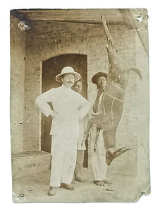 [BELGIAN CONGO / HUNTING] [Early photograph showing Joseph DeVos, a Dutch hunter in Belgian Congo, in front of an antelope hunted and hung from the ceiling by the feet]